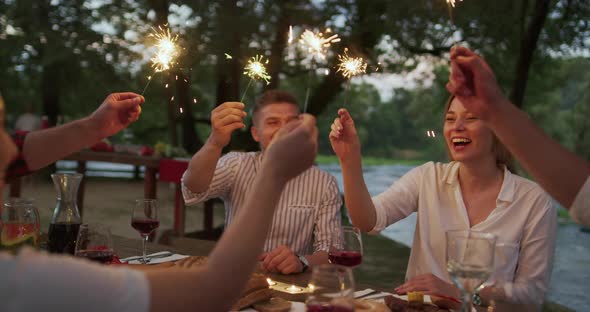Youth Friendship Concept  Hands Toasting Red Wine Glass Beside River at Nightime alt