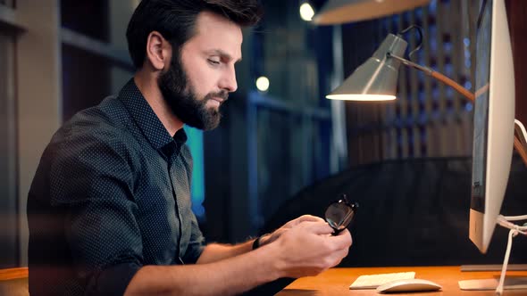 Software Developer Overworked On Computer Late Night. Businessman Wearing Glasses. Modern Office. alt
