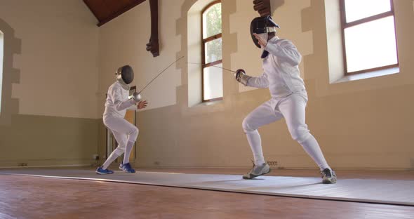 Fencer athletes during a fencing training in a gym alt
