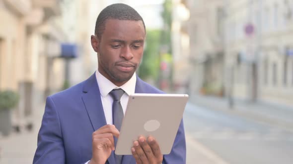 Outdoor Attractive African Businessman Using Tablet in Street alt