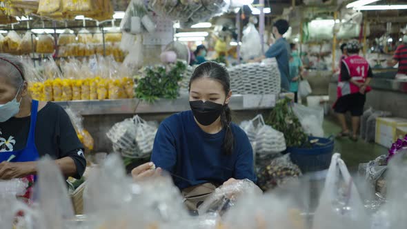A Senior And Young Flower Seller Making Aesthetic Thai Garlands Within Bangkok Central Flower Market alt