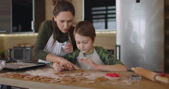 Young Mother and Son Cooking Cookies Together in the Kitchen alt