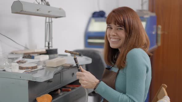 Cheerful Jeweler Holding Blowtorch Smiling On Camera alt