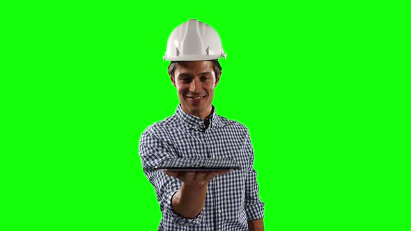 Front view of site worker holding a digital tablet with green screen alt