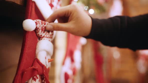 Ornament Red Sock with a Snowman Hangs Over the Fireplace Women's Hands Correct alt