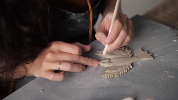 Close Up Top View of Potter Female Hands Working on Details of a Clay Handcraft Bird alt