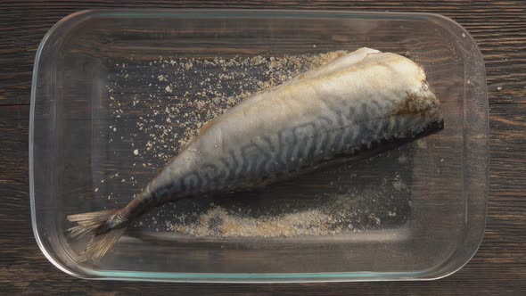 Male Hands are Flipping and Sprinkling a Red Char Fish with Lemon Zest and Salt alt