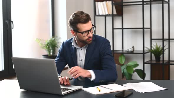 Clever Ambitious Young Businessman in Formal Suit Working with a Laptop alt
