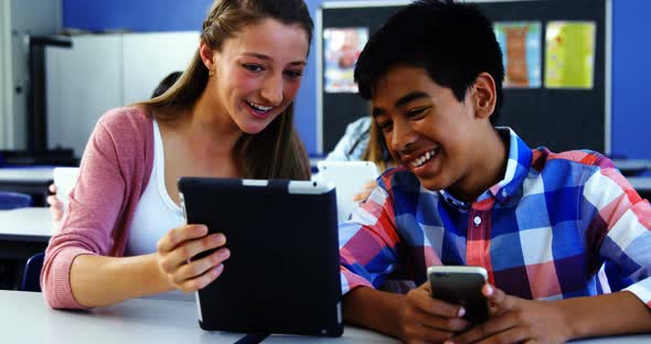 Students using digital tablet and mobile phone in classroom alt
