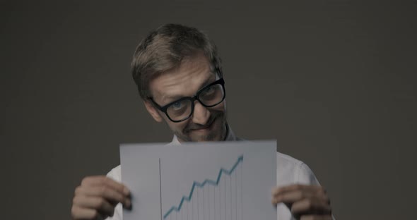 Happy businessman holding a successful financial chart
