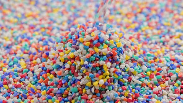 Crushed Colored Stones Puring on Flat Surface Forming a Small Pile in Slomo alt