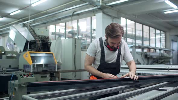 Portrait of Professional Engineer Man 30s Wearing Overall Working with Equipment and Measuring alt