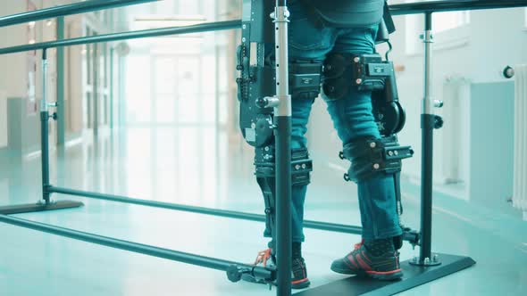 A Person is Training to Walk in the Hospital While Wearing Exoskeleton alt