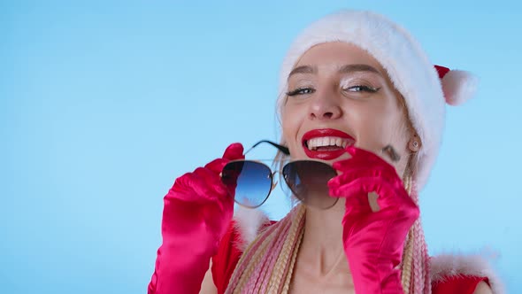 Cute Woman in Santa Claus Costume and Sun Glasses