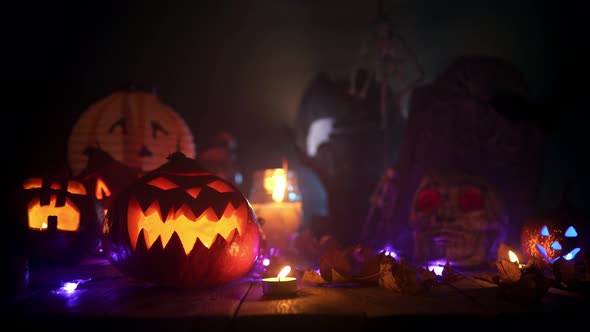 Flashlight Beam Is Lighting Halloween Pumpkins and Candles at the Table alt