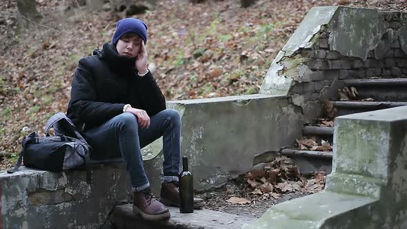 Upset Teenager Drinking Alcohol From Bottle in Park, Suffering From Depression alt