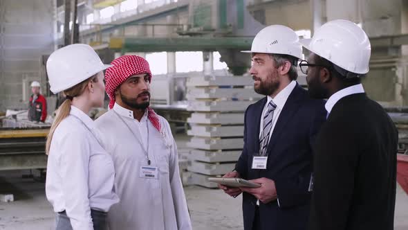 Middle Eastern engineer sharing experience at building factory