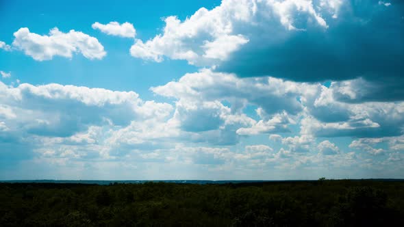 White Fluffy Clouds Slowly Float Through the Blue Daytime Sky Timelapse alt