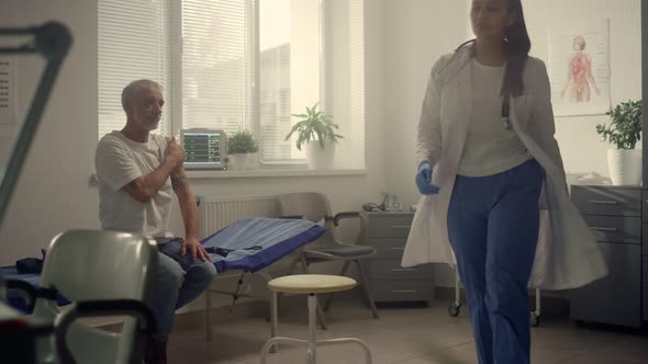 Mixed Raced Doctor Consulting Elderly Patient Vaccine Injection in Health Clinic alt