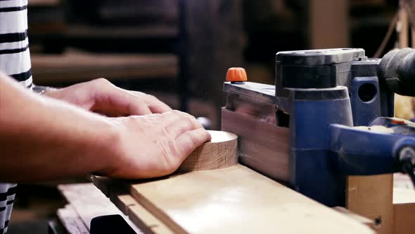 Craftsman Working with Grinding Machine at Wood Workshop Hands Closeup