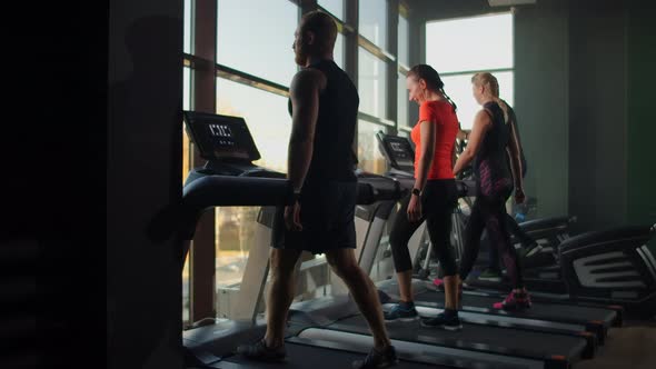 Group of People in the Gym Training on Treadmills in Slow Motion alt