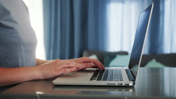 Freelancer working on laptop in modern apartment. Student typing on computer, smart professional emp alt