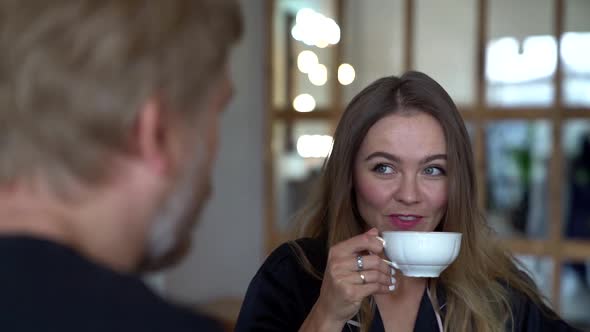 Man and Woman Are Drinking Coffee at Morning at Home Kitchen and Smiling