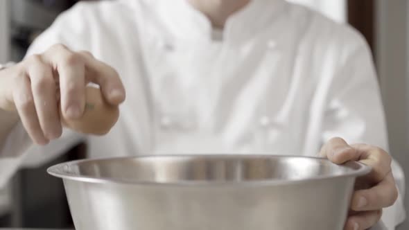 Closeup of Hands of a Chef Breaking Eggs