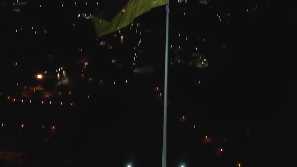 Gorgeous Aerial View of Night Kyiv and the Ukrainian Flag Flailing in the Wind alt