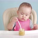 Baby eats vegetable puree on his own while sitting on a feeding chair - VideoHive Item for Sale