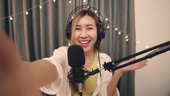 Asian influencer recording a vlog using podcast microphone for vlogging and streaming.