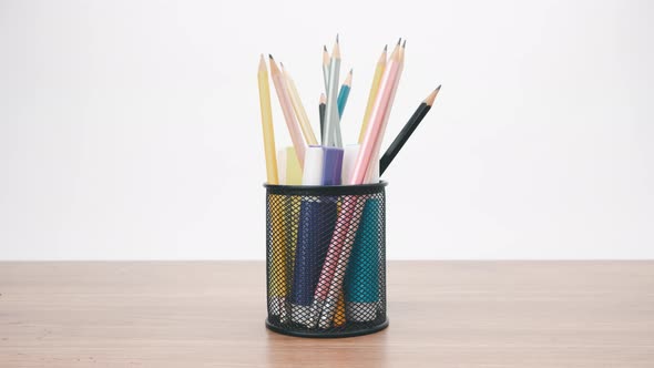 Stop motion animation colored pencils in black transparent stand
