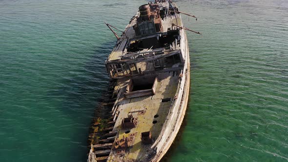 A Wrecked Wooden Ship Lies on the Seashore Covered with Rust alt