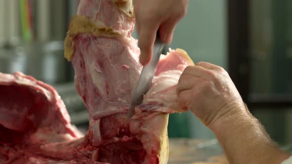 Close Up Butcher Removing the Skin From Pig Leg alt