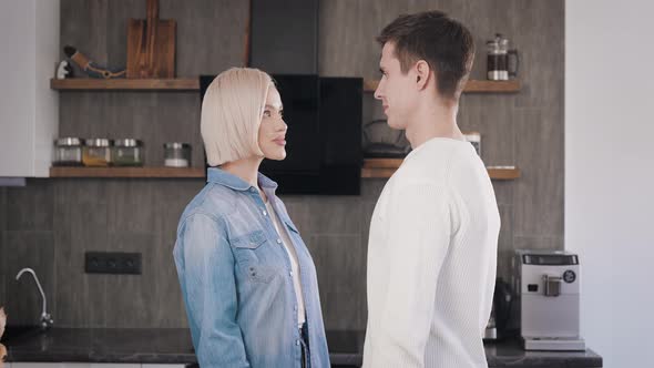 Beautiful Young Couple Emotionally Hugs in the Kitchen alt