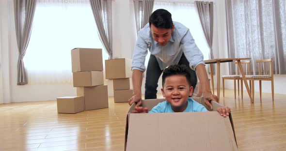 Family Is Having Fun With Cardboard Boxes In New House alt