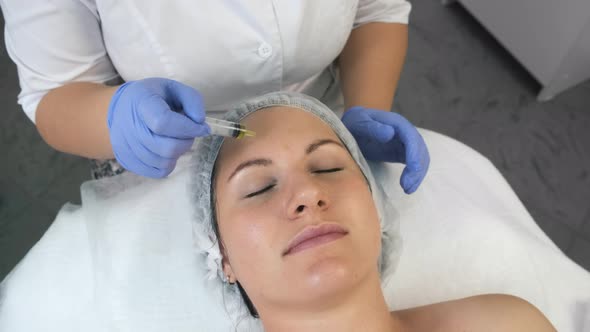 Cosmetologist is Applying Yellow Peeling on Woman's Face in Beauty Clinic
