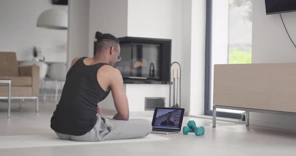 African American Fitness Trainer Using Laptop for Online Training with Client During Coronavirus alt