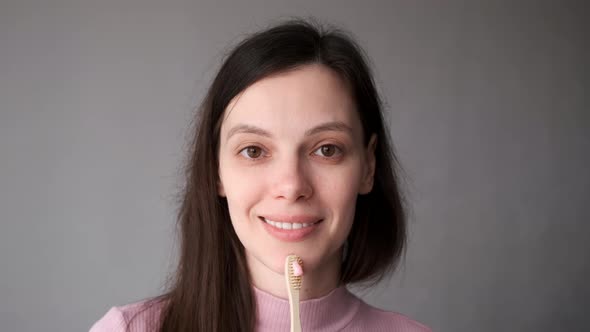 Smiling Woman with Organic Bamboo Toothbrush and Toothpaste in Her Hands