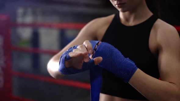 Woman Fighter Wraps Her Hands with Boxing Bandages alt
