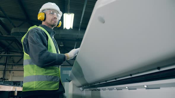 Metal Tile Is Getting Bent By Factory Equipment Under Worker's Control alt