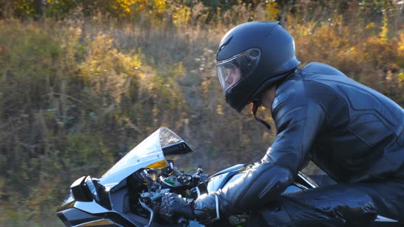 Man in Helmet Riding on a Motorbike at Highway with Sun Flares at Background alt
