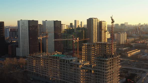 Several Construction Tower Cranes in the Process of Building Houses in a New Residential Complex at