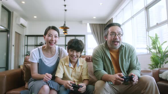 happiness cheerful asian family play video game together at home fun and excited