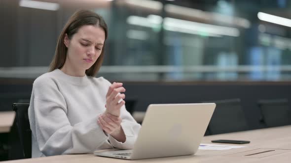 Woman having Wrist Pain while Typing on Laptop alt