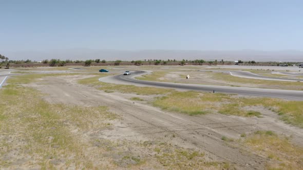 A drone captures aerial video of multiple cars cruising on the streets of Palm Springs Valley, Calif alt
