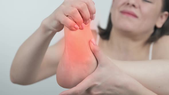 Woman Touching Foot in Pain Close Up