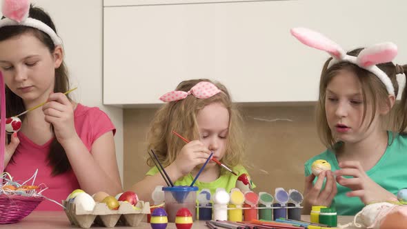 Three Girls are Preparing for the Easter Holiday and Paint Eggs with Paint