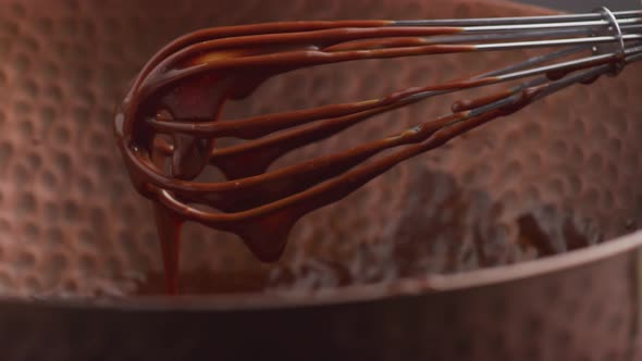 Melted chocolate dripping from whisk