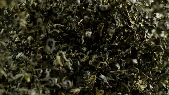 Super Slow Motion Shot of Dried Green Tea Explosion Isolated on Black Background at 1000Fps alt